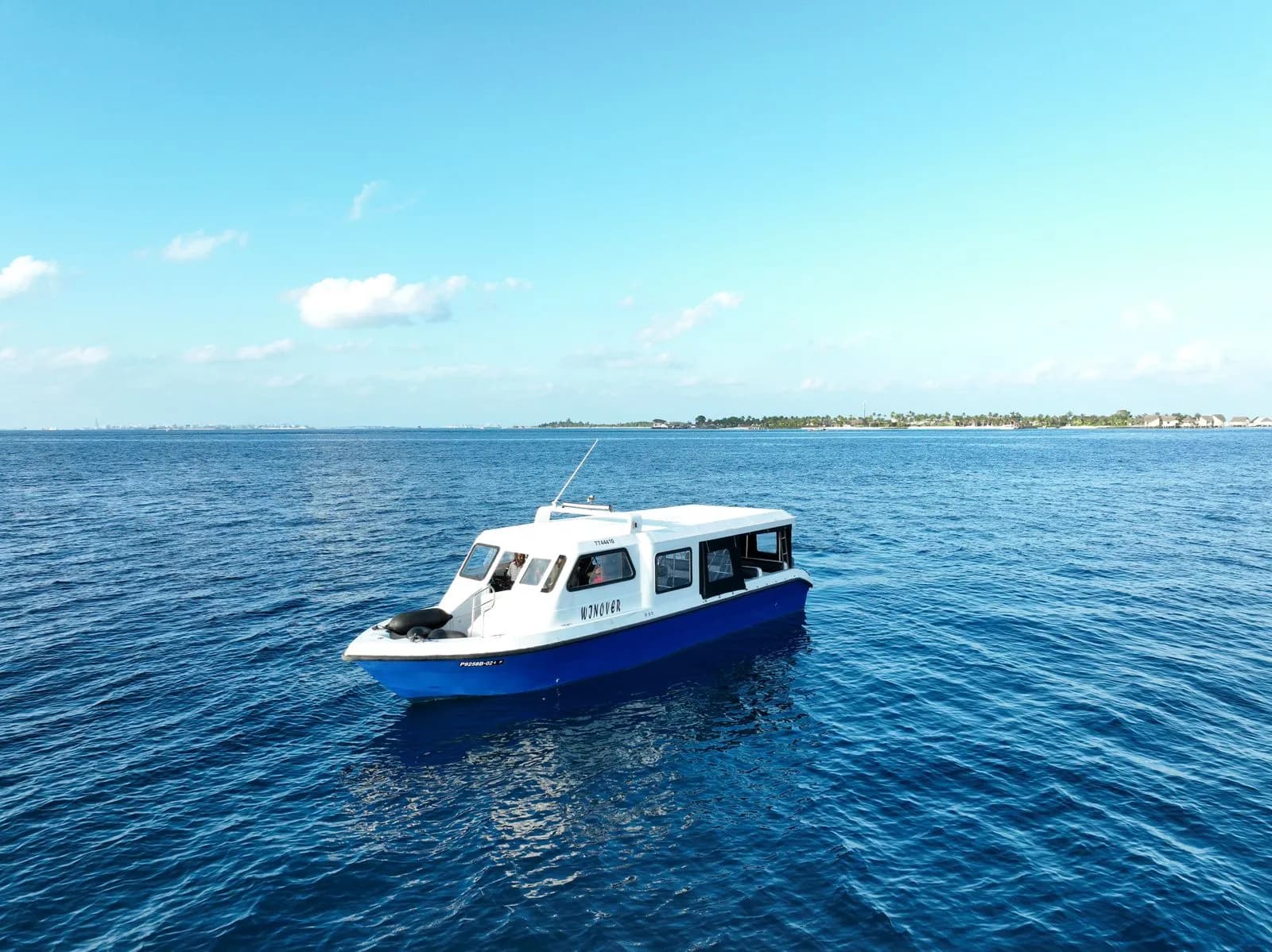 Speedboat crossing a turquoise Maldives lagoon toward island resorts