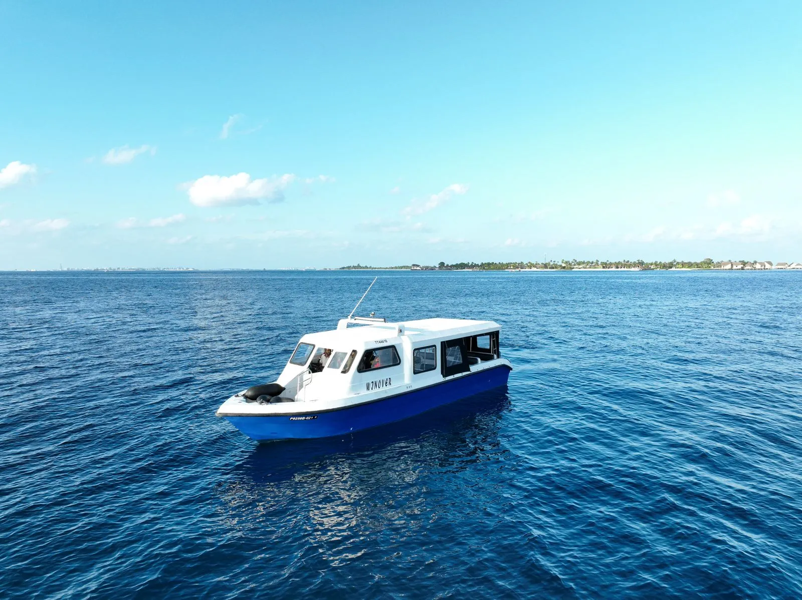 Speedboat crossing a turquoise Maldives lagoon toward island resorts